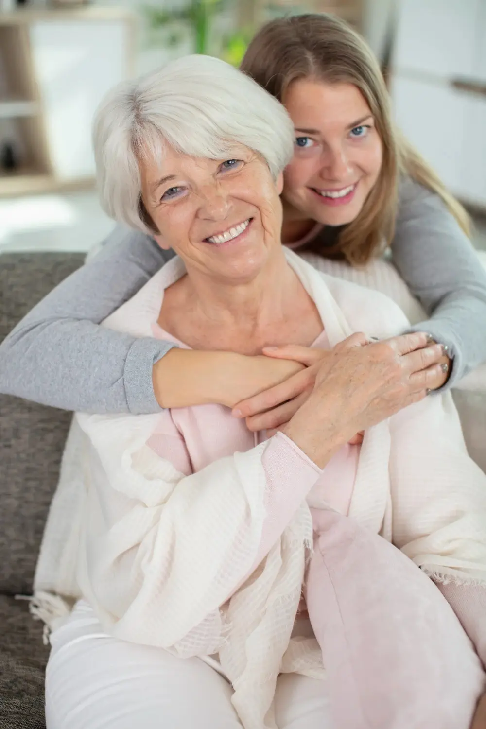 Charmante blonde Dame umarmt ihre Mutter
